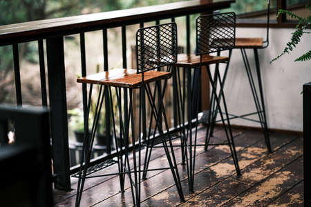 Tall table - Wooden table steel legs simplistic, tall bar stools in stylish kitchen with wooden cupboards.の写真素材