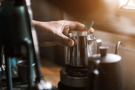 Barista preparing coffee using coffee maker and drip kettle. Man making coffee. Alternative ways of brewing coffee. Coffee shop, good quality coffee beansの写真素材