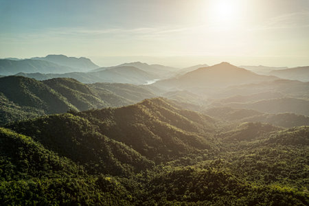 Green mountains and bright sky, Cumulus clouds over a green mountain valley with a winding road and...