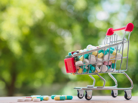 shopping trolley full of medicine with pills and capsules on bokeh background. Healthy and medical concept.の写真素材
