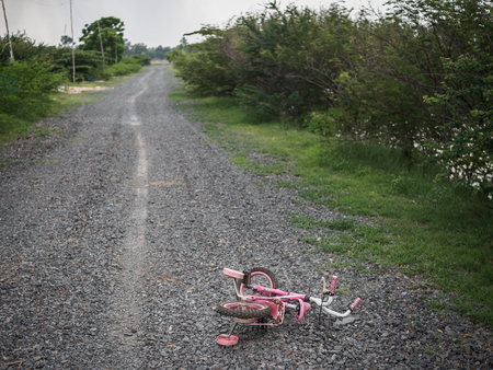 Children's bikecycle and shoe on stone road. missing children concept. international missing children's day.の写真素材