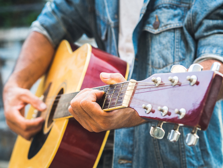 handsome musician playing acoustic guitar on blur background. World music day. music and instrument...