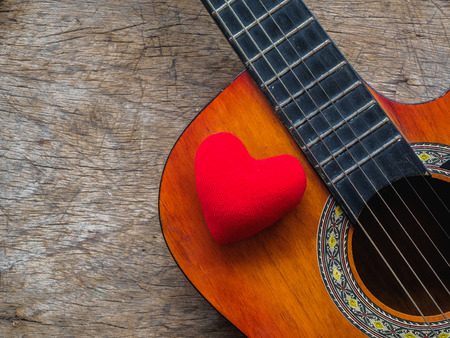 The guitar and red heart on wooden texture background. Love, Music day concept.の写真素材