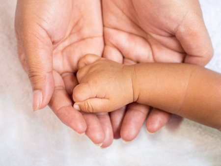 Close up baby hand on mother's hands. Love and family concept.の写真素材