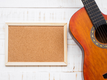 The guitar and board on white wooden texture background. Love, Music day concept.の写真素材