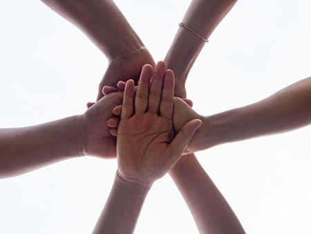 Closeup United hands on white background. United, Friendship, Teamwork, Harmony and Help Concept.の写真素材