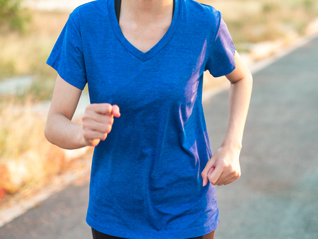 Close up soft focus of young woman running outdoor in the park.の写真素材
