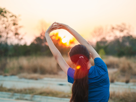 Young woman stretching before running. Sport girl preparing to run in the park.の写真素材