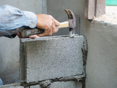 professional construction worker laying bricks with cement.の写真素材