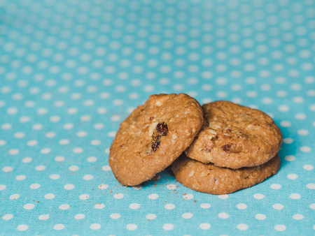Oatmeal and raisin cookies on pastel blue polka dot background.