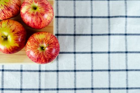 Fresh red apples on wooden cutting board and towel background.の写真素材