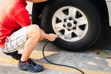 Close up of asian man inflating tire in the gas station.の写真素材
