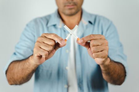 Man hand holding crossed cigarettes.の写真素材