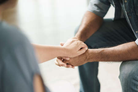 Female friend or family sitting and hold hands during cheer up to mental depress man, Psychologist...