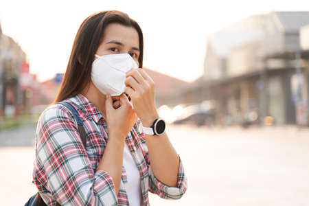 Asian woman wearing N95 face mask to protect pollution PM2.5 and virus. COVID-19 Coronavirus and Air pollution pm2.5 Healthcare and medical concept.の写真素材