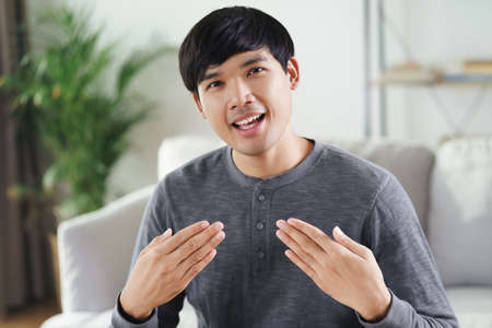 Young Asian deaf disabled man using Sign Language to communicate with other people.の写真素材
