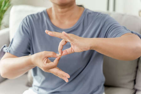 Mature Asian deaf disabled woman using Sign Language to communicate with other people.の写真素材