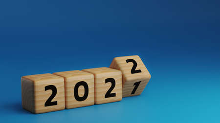 start to year 2022. wooden cube block flipping to change 2021 year to 2022 year on blue background with copy space. happy new years concept. 3D Render Illustration.の写真素材