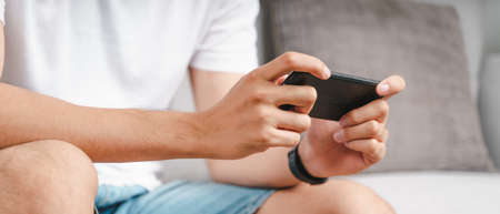Closeup of happy man using a smartphone, searching, browsing, social media, message, email, play...