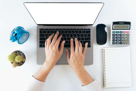 top view of woman hands typing on laptop keyboard on the table at home office or workplace.