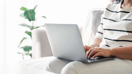 Close up of woman using laptop at home office or workplace.