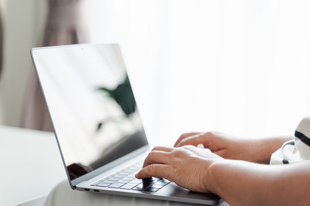 Close up of woman using laptop at home office or workplace.