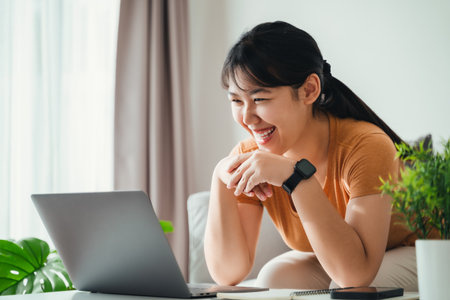 Happy woman using laptop at home office or workplace.