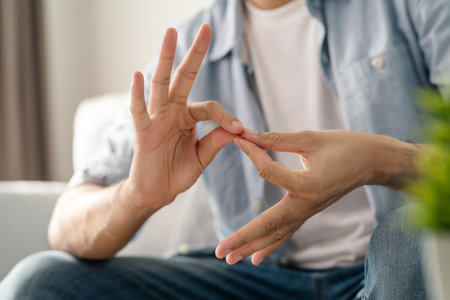 Happy young deaf man using sign Language to communicate with other people.の写真素材