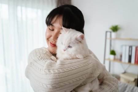 Happy Woman Playing with Cat in Cozy Living Room at Home.の写真素材