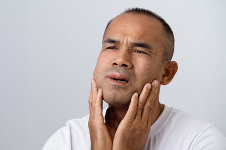 The man has facial swelling due to an allergic reaction to triggers such as insect bites stings, food, or medication. Close up of a swollen face.の写真素材