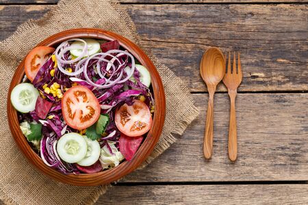 fresh vegetable salad in wooden bowl  on old wooden background,Top view の写真素材