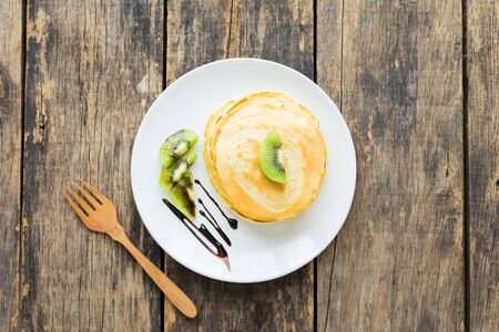 Delicious pancakes with kiwi on wooden table. top viewの写真素材