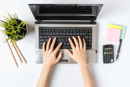 Top View of Businesswoman Working on a White office desk with Computer and office Supplies