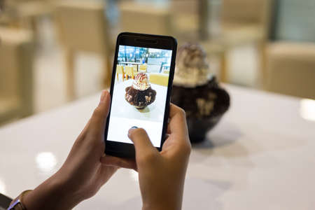 Woman taking a photo of dessert chocolate bingsu