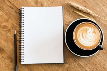 Top view empty notebook and coffee cup on wooden table top view.の写真素材