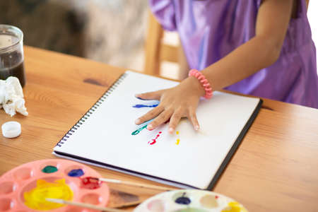 Asian little girl with painted hands In the houseの写真素材