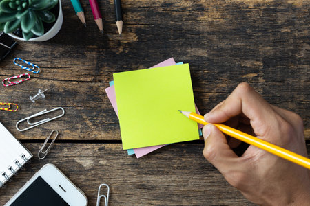 Top view man hands writing on notepad working on desk wooden