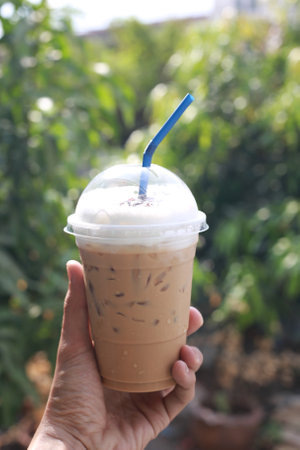 Men's hand holding a iced coffee mugの写真素材