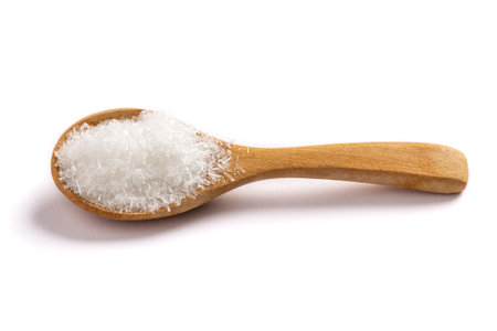 monosodium glutamate, MSG on wooden spoon Isolated on white background