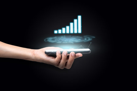 Close up hand of a business man using a smartphone. That shows analysis of sales data and graphs for...