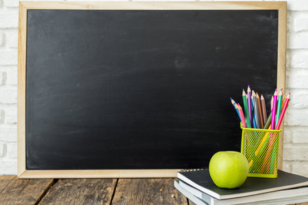 Books and chalkboard on wooden backgroundの写真素材