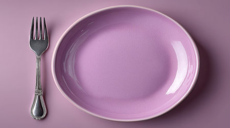Empty pink plate with silver fork on purple background. Top view.の素材