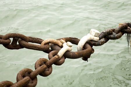 Rusty Chains Locked Together at a Ship Dockの写真素材