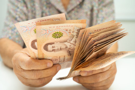 Asian elder senior woman patient holding Thai banknotes money in her hand, Cost of living and...