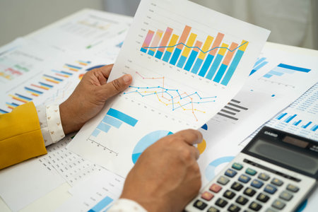 Asian business woman working with financial graph.