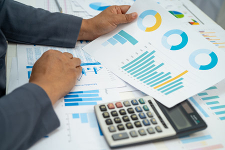 Asian business woman working with financial graph.