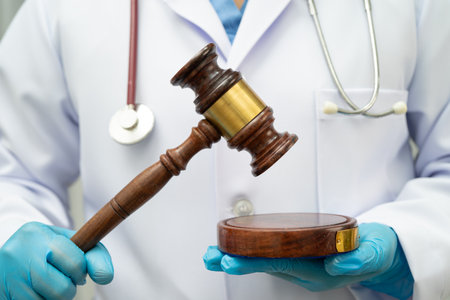 Asian doctor holding court hammer for and crime law justice, forensic medicine.の写真素材