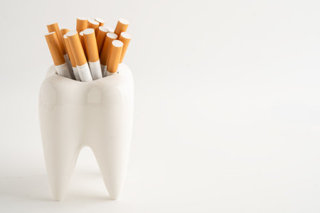 Cigarette in teeth model isolated on white background, damage the health of your teeth, No smoking.