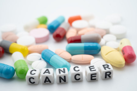 Cancer word with pills and capsules medical drug.