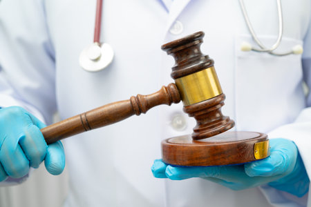 Asian doctor holding court hammer for and crime law justice, forensic medicine.の写真素材
